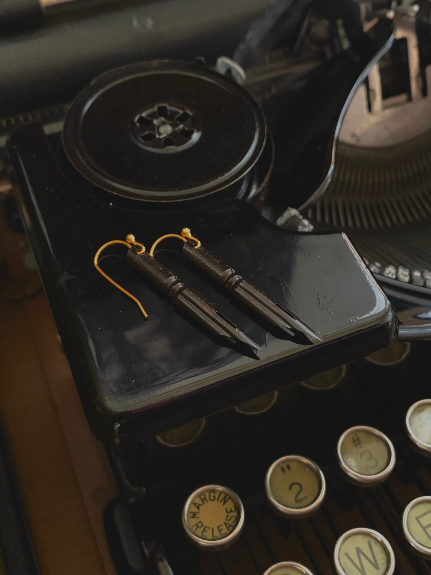 Pendientes góticos negros con punta de pluma francesa y alambres chapados en oro. Adornos oscuros y melancólicos para las orejas de estilo monótono.